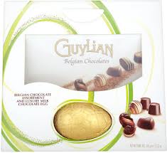 A white box of Guylian Belgian Chocolates with assorted chocolates pictured on the front. A gold-wrapped chocolate egg is visible through a cut-out window. The packaging features green accents and text describing the contents.