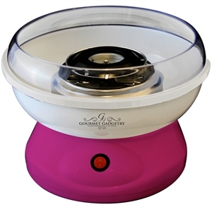 A pink and white candyfloss machine with a clear plastic bowl and a metal spinning head, featuring a red power switch on the front. The base is bright pink, and the logo “Gourmet Gadgetry” is printed on the bowl.