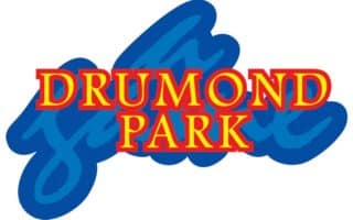 The image shows the Drummond Park logo, featuring the words "DRUMMOND PARK" in bold, yellow upper-case letters with a thick red outline, placed in front of a large, stylised blue script background.
