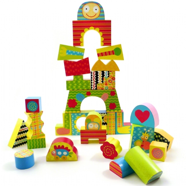 A colourful assortment of patterned wooden blocks is stacked in playful shapes, including rectangles, arches, circles, and triangles. Some blocks feature smiling faces, flowers, stripes, and hearts. Others are scattered around the base, inviting imaginative play.
