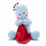 A soft blue plush toy with round limbs, pink cheeks, and small blue and red tufts on its head sits holding a large red blanket. The toy is sitting upright facing forwards, appearing friendly and comforting.