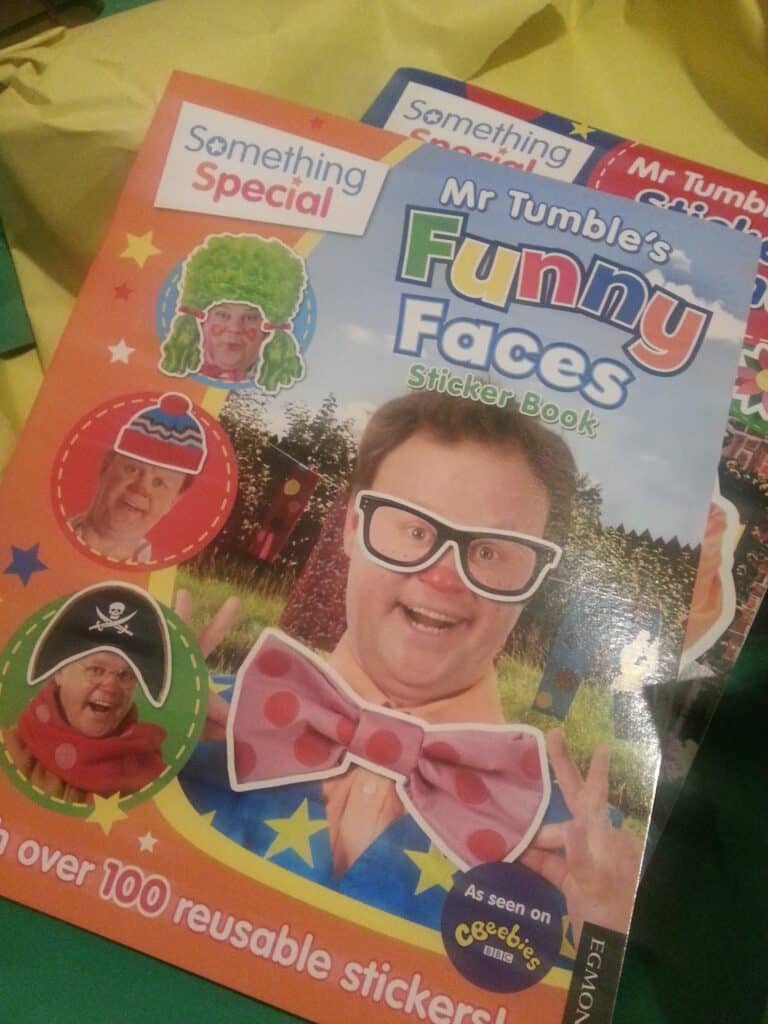 A colourful sticker book cover titled "Mr Tumble's Funny Faces Sticker Book" from the "Something Special" series shows Mr Tumble in quirky glasses, a big bow tie, and surrounded by silly face stickers, including a clown, pirate, and chef. Text mentions "over 100 reusable stickers.