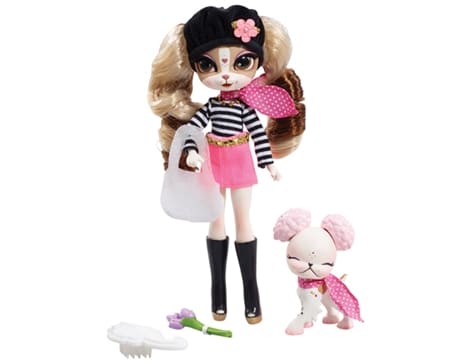 A stylish dog doll with long wavy hair wears a black beret, striped shirt, pink skirt, pink scarf, and black boots. She holds a white bag and is accompanied by a small white poodle with a pink scarf. Accessories include a brush and a green bone toy.
