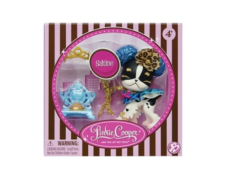 A boxed Pinkie Cooper and The Jet Set Pets toy set. The box has pink and brown stripes and a window showing a dog figurine with blue ears, a leopard-print bow, gold accessories, a blue chair, and a tiara. The set is labelled for ages 4+.
