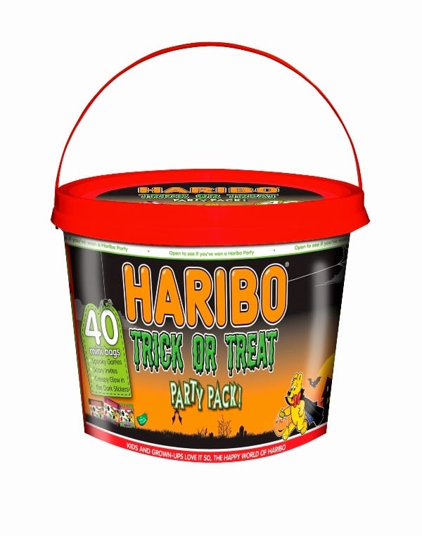 A bucket with a red lid and handle, labelled "Haribo Trick or Treat Party Pack." The bucket features Hallowe’en-themed graphics, including a pumpkin and a cartoon bear, and advertises “40 mini bags of gummy sweets.” The background is black and orange.