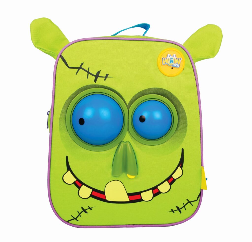 A bright green rucksack designed to look like a cartoon monster face, with two large bulging blue eyes, a yellow nose, stitched details, big yellow teeth, floppy fabric ears, and a yellow “WOW” button on the top right corner.