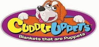 A cartoon dog with brown and white fur leans over an oval purple sign. The yellow and blue text reads “Cuddle Uppets.” Below, in white letters, it says, “Blankets that are Puppets.”.