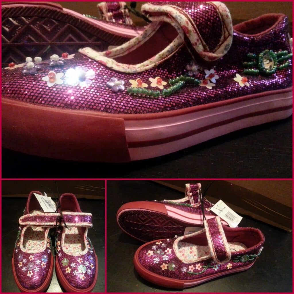 A pair of shiny pink children’s Mary Jane shoes with floral embroidery, sequin detailing, and pearl accents. The shoes have a pink strap with a floral print, thick pink soles, and a navy floral interior. Multiple angles of the shoes are shown.