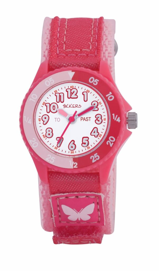 A pink children’s wristwatch with a red fabric strap and a pink butterfly patch. The watch face features large red numbers, “TO” and “PAST” labels, and a silver crown on the right. The brand name “Tikkers” is on the white dial.