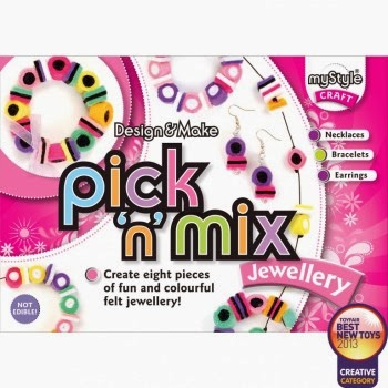 A pink craft kit box labelled "myStyle Design & Make pick 'n' mix Jewellery." It shows colourful felt beads, necklaces, bracelets, and earrings. Text says “Create eight pieces of fun and colourful felt jewellery!” with awards and a "NOT EDIBLE!" warning.