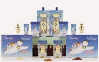 Assorted “The Snowman” themed Christmas chocolate gift sets featuring boxes, chocolate bars, snowman-shaped sweets, and mugs, all decorated with illustrations of the Snowman character from the classic Christmas story, arranged in a festive display.