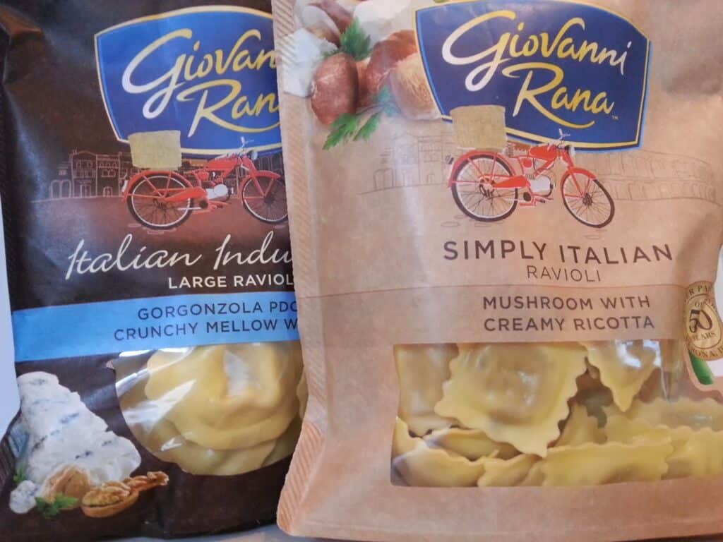 Two packs of Giovanni Rana ravioli are side by side. The left bag is blue, labelled “Italian Indulgence Gorgonzola PDO with Crunchy Mellow Walnuts.” The right is tan, labelled “Simply Italian Mushroom with Creamy Ricotta.” Both show images of ravioli.