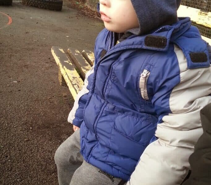 A boy sitting on a bench.