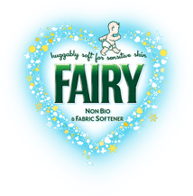 A heart-shaped border with blue and yellow flowers surrounds the text “huggably soft for sensitive skin FAIRY Non-Bio & Fabric Softener.” At the top is a cartoon baby outlined in blue. The overall feel is gentle and soft, emphasising sensitivity.