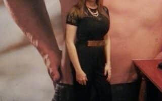 A woman standing in front of a poster.