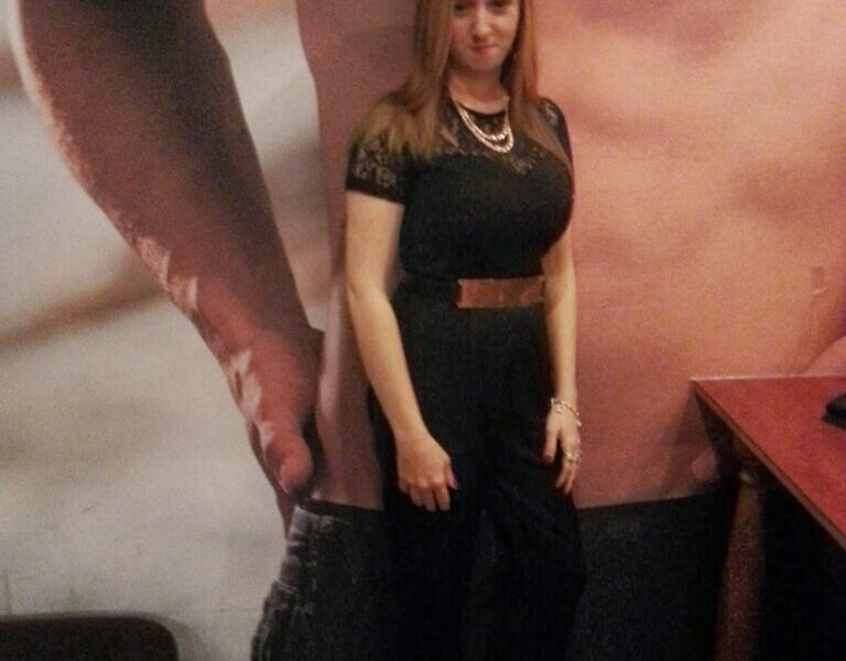 A woman standing in front of a poster.