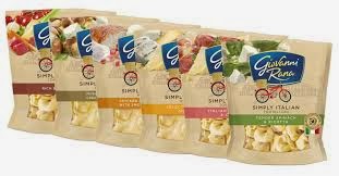 Five packs of Giovanni Rana Simply Italian tortellini are displayed side by side, each with differently coloured labels representing various flavours. The packs are beige with clear windows showing the pasta inside and a blue Giovanni Rana logo at the top.