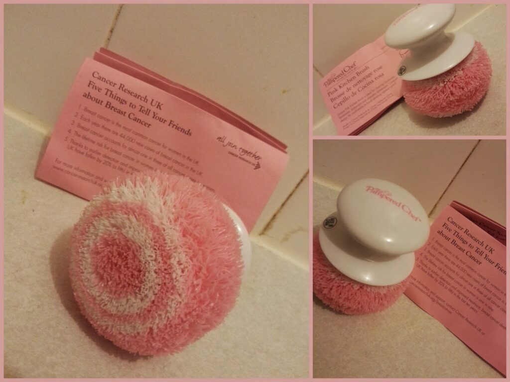 A fluffy, round pink and white object resembling a makeup puff sits beside a pink Cancer Research UK leaflet about breast cancer from three different angles. The leaflet offers information on what to tell friends about breast cancer.