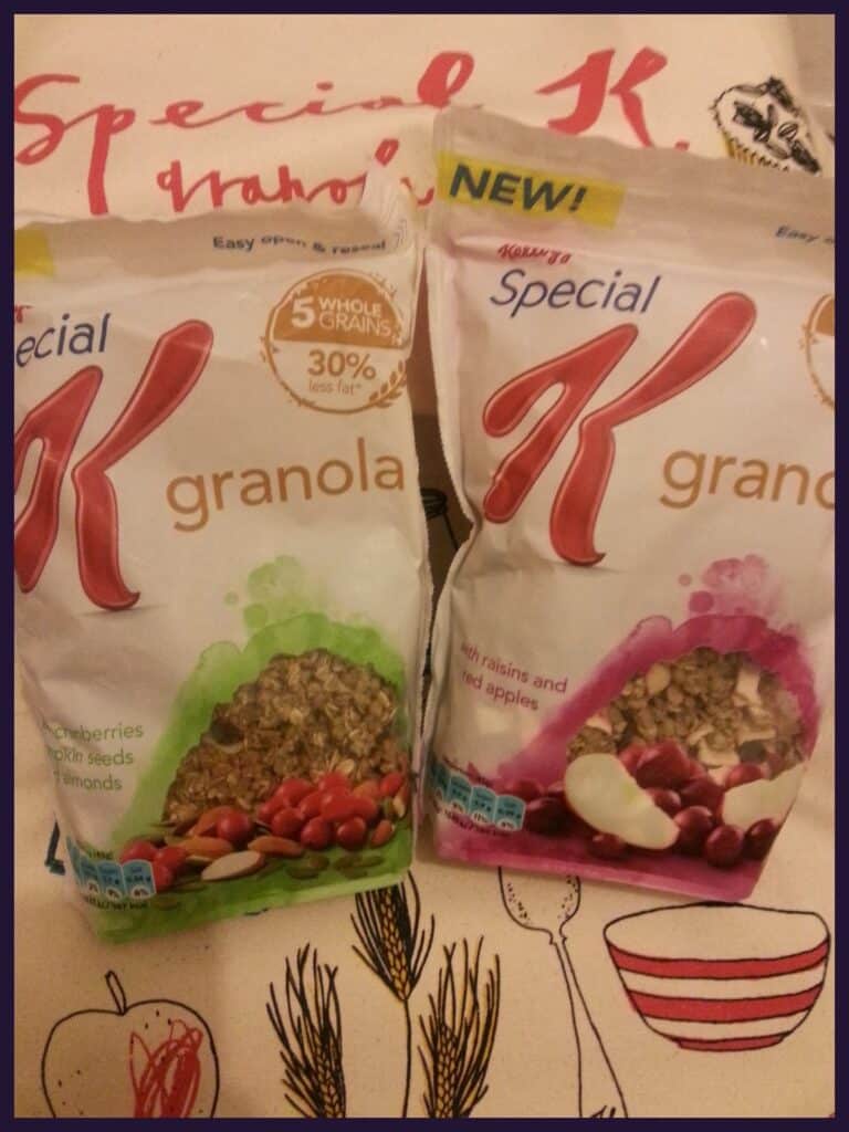 Two Kellogg’s Special K granola bags stand upright. The left bag is cranberry, pumpkin seed, and almond flavour; the right bag is with raisins and dried apple. Both bags display visible granola through a clear window and colourful, fruit illustrations.