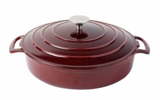 A deep, round, dark red enamelled cast iron casserole dish with two side handles and a matching lid. The lid has concentric ridges and a silver knob on top. The dish sits on a white background.