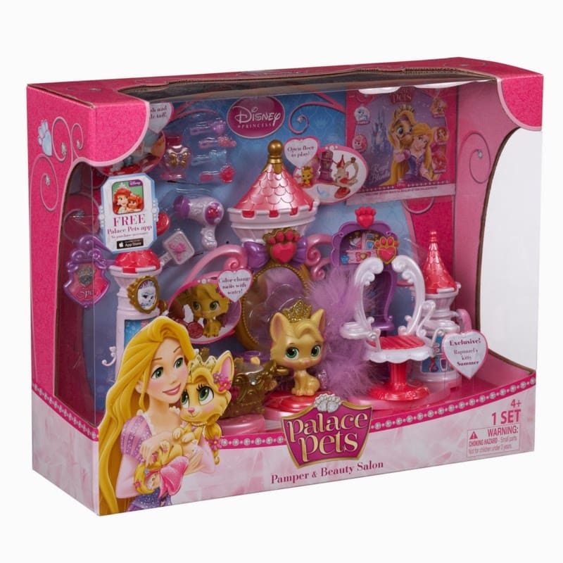 A boxed Palace Pets Pamper & Beauty Salon playset. The pink packaging features Disney princess graphics and a clear window showing toy pets, a dressing table, accessories, and beauty items inside. Age label: 4+. Branding and product details are visible.