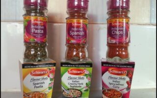 Three Schwartz spice blends in clear bottles with red lids are displayed on top of their matching Flavour Shots boxes: Spanish Pasta, Chips, and Chicken. The boxes below them are Spanish Paella, Creamy Herb Tagliatelle, and Spicy Jalfrezi Curry.