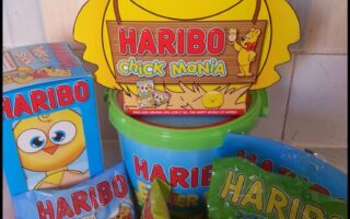 A collection of Haribo sweets with Easter-themed packaging, including a large yellow chick-shaped box labelled "Chick Mania," a green bucket, a blue box of "Eggs," and three packets of gummy sweets labelled "Jelly Bunnies," "Funny Mix," and "Farm Animals.