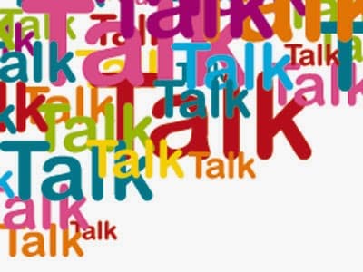 The image shows the word “Talk” repeated in various sizes, fonts, and colours, overlapping each other. The background is white, and the vibrant colours include red, pink, blue, green, orange, and yellow.