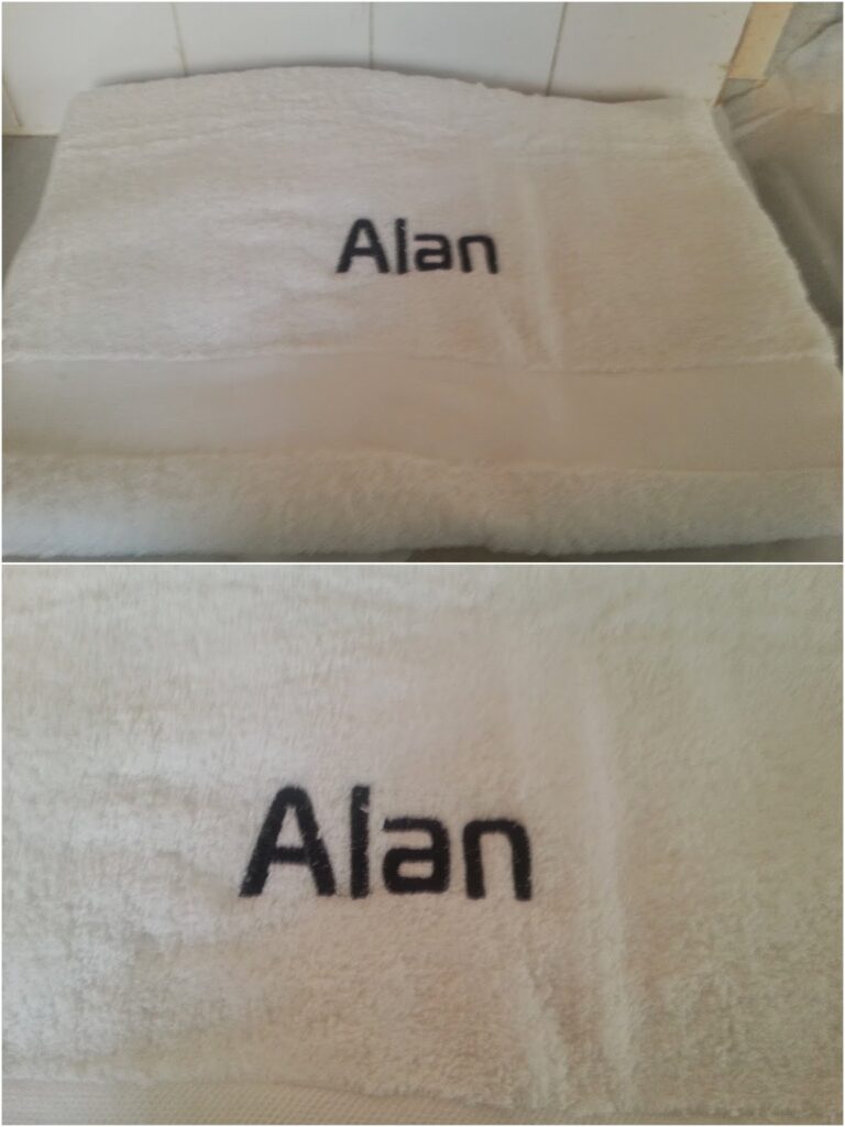 Two photos show a white towel with the name “Alan” embroidered in black thread. The top image displays the entire folded towel, whilst the bottom image provides a close-up of the embroidered name, highlighting the texture of the fabric.