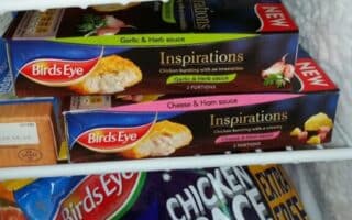 A freezer drawer filled with Birds Eye frozen foods, including two boxes of Inspirations meals (Garlic & Herb, and Cheese & Ham sauces) and a bag of Chicken Space Shapes. Other frozen items are partially visible in the background.