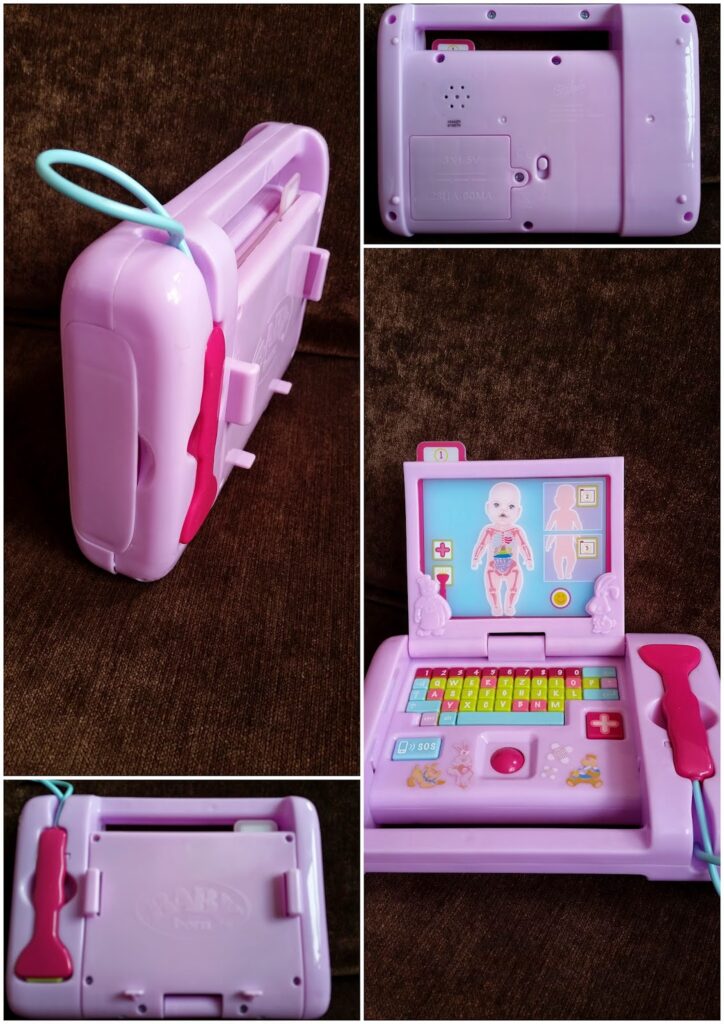 A collage shows a pink and purple plastic toy medical laptop with a stethoscope. One image shows the toy closed, others show the back and side, and the main image displays it open with a screen showing a cartoon body diagram and colourful buttons like a keyboard.