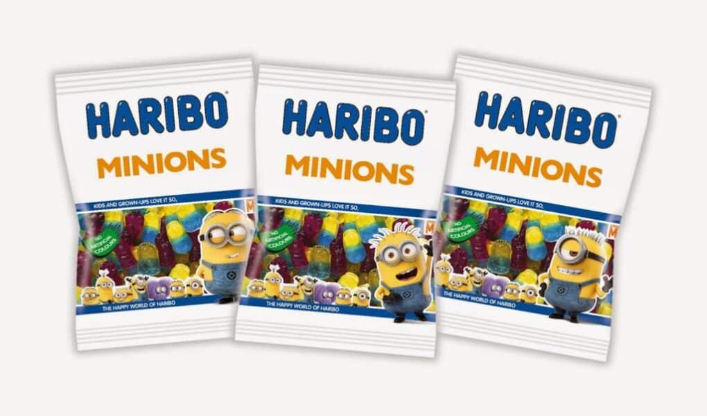 Three bags of HARIBO Minions gummy sweets are displayed side by side. Each white bag features colourful gummy sweets and images of Minions characters from the "Despicable Me" films on the front, with "HARIBO MINIONS" written in bold blue and yellow letters.