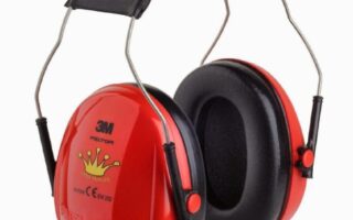 A pair of red 3M ear defenders with black cushioned ear pads and a black padded headband. The ear defenders feature a yellow crown design and certification markings on the side. The metal frame connects the ear cups to the headband.