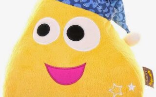 A yellow, triangular plush toy with big round eyes, a pink smiling mouth, white star patterns, and a blue nightcap decorated with moons and stars. The toy has a cheerful, cartoonish face and a soft, fuzzy texture.