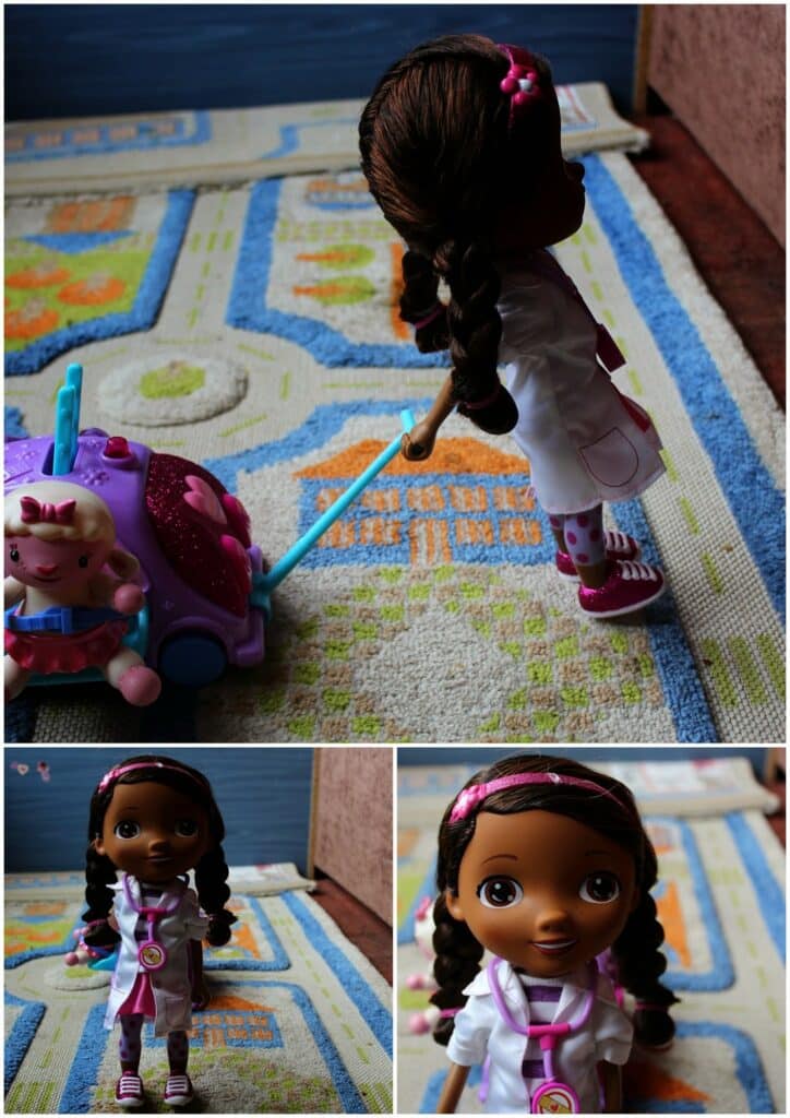 A dark-skinned doll with braided hair, wearing a white doctor's coat, pink shoes, and a stethoscope, stands on a patterned rug. She pulls a purple toy suitcase. Two smaller close-ups below show her smiling face and full outfit.