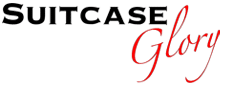 The image shows the words "Suitcase Glory." "Suitcase" is written in bold black uppercase letters, whilst "Glory" is in a red, elegant cursive font. The background is white.