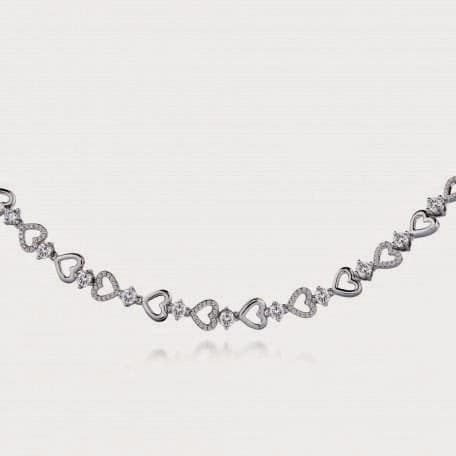 A delicate silver necklace featuring alternating open and diamond-studded heart-shaped links, connected by small sparkling round stones, evenly spaced along the chain against a light, plain background.