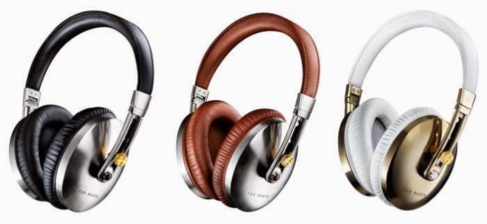 Three pairs of over-ear headphones are shown: one with black leather and silver accents, one with brown leather and silver accents, and one with white leather and gold accents. All have a sleek, modern design and padded headbands.