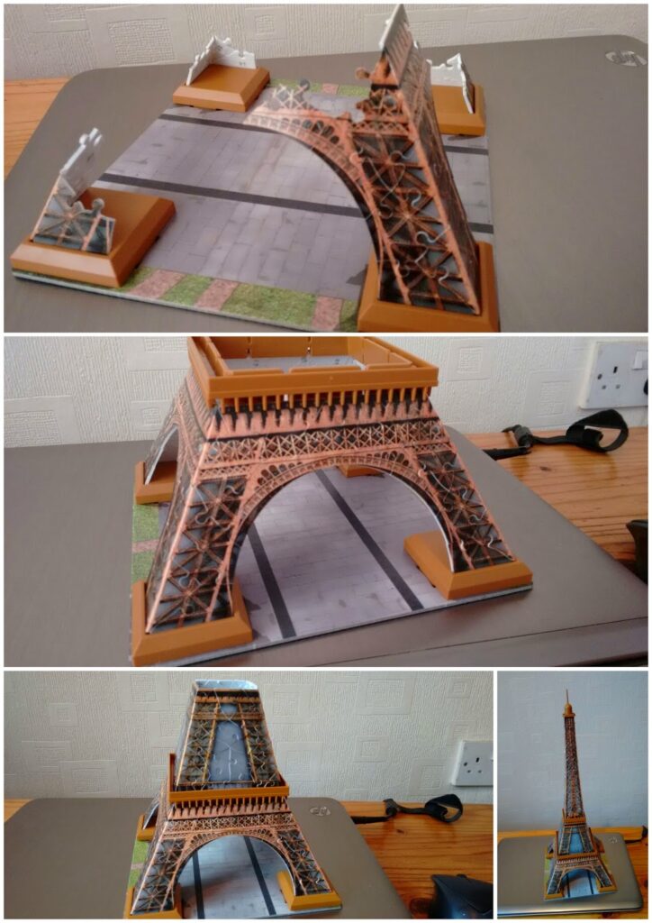 A four-panel collage shows the assembly of a small 3D puzzle model of the Eiffel Tower on a wooden table. The first three panels display close-ups of its construction, whilst the final panel shows the completed tower standing upright.