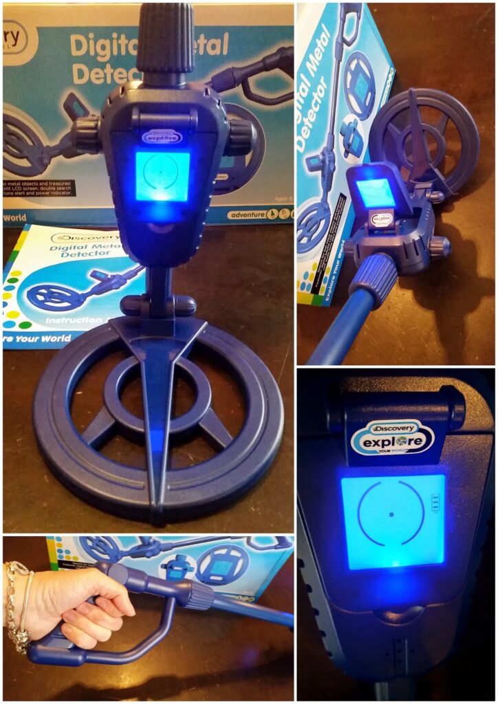 A blue “Discovery Explore” digital metal detector toy is shown from several angles. It features a circular coil, a screen with a glowing blue display, and an instruction booklet. A hand holds the device in one image. The packaging appears in the background.