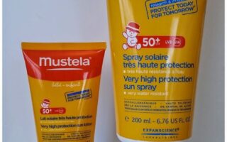 Two tubes of Mustela suncream are standing upright against a plain background. The smaller tube is 40ml and the larger is 200ml. Both feature red and yellow packaging, SPF 50+ labels, and text indicating "very high protection" for babies and children.
