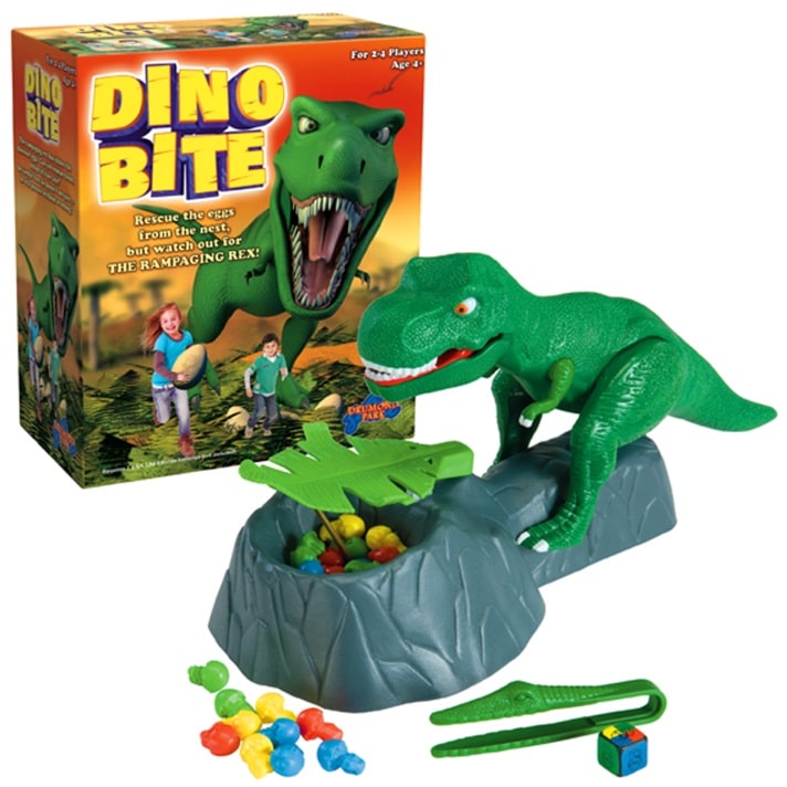 Box and components of the Dino Bite game. The box shows a roaring T. rex and children playing. The game features a plastic green T. rex over a nest with colourful eggs, tweezers, and a die. The goal is to rescue eggs without getting "bitten" by the moving T. rex.