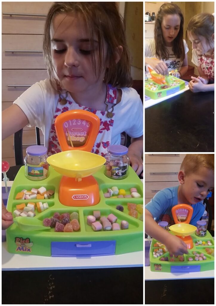 A young girl plays with a toy sweet shop set, sorting colourful sweets on a counter with a yellow scale. Smaller images show her with another girl and a young boy, all engaged and interacting with the play set on a table.