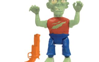 A green zombie toy with bulging eyes, a red dot on its forehead, and a red shirt with a green graphic, blue trousers, and raised arms. Next to it is an orange toy gun. Both items are on a white background.