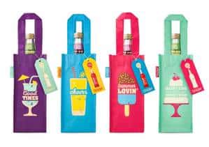 Four colourful gift bags each holding a wine bottle. The bags are purple, blue, pink, and green, with playful drink and dessert illustrations and cheerful messages: “Good Times,” “Cheers,” “Summer Lovin’,” and “Let’s Celebrate.” Each has a matching tag.