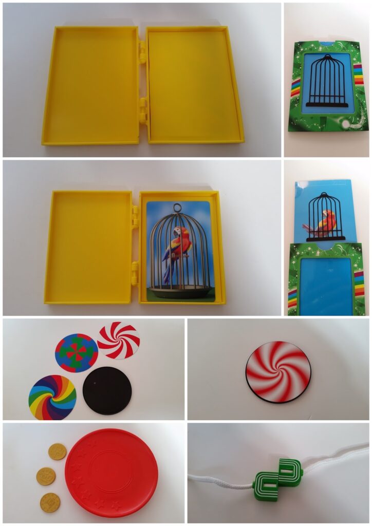 Collage of colourful magic trick props: a yellow box, cards depicting a birdcage and parrot, round spinning optical illusion disks, gold coins, a red disk, a green knot puzzle, and two striped card envelopes with birdcage designs. All items are on a white background.