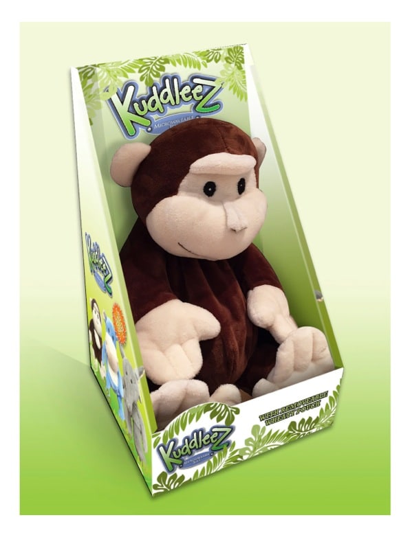 A brown and beige plush monkey toy sits upright in green and white packaging labelled "KuddleeZ" with jungle leaves and cartoon animals. The monkey has rounded ears, large eyes, and a gentle smile, filling the box with its soft, floppy arms and legs.