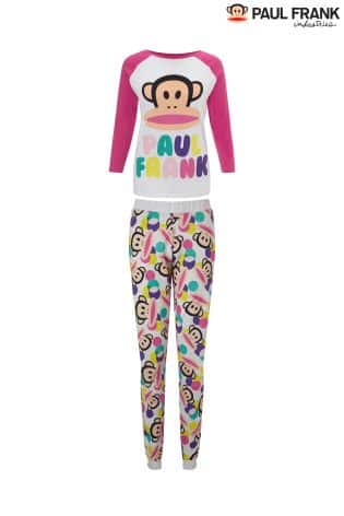 A two-piece Paul Frank pyjama set featuring a white and pink long-sleeve top with a large Julius the monkey face and colourful "PAUL FRANK" text. The matching trousers are covered in a playful, multicoloured Julius print. Brand logo in the top right corner.