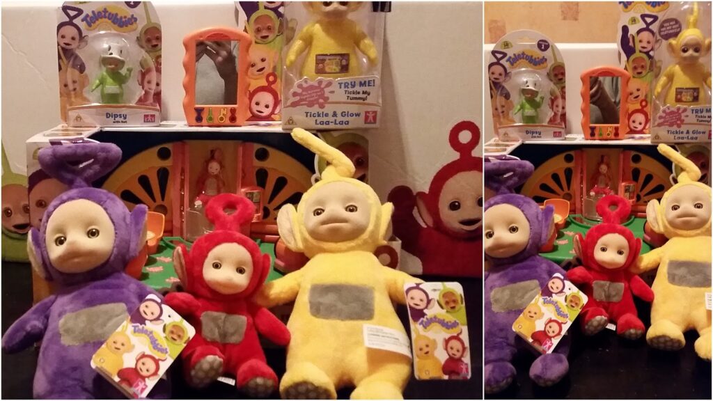 Teletubbies toys are displayed: plush figures of Dipsy (green), Po (red), Laa-Laa (yellow), and Tinky Winky (purple), plus boxed light-up versions behind them. The toys are arranged in front of a colourful background.