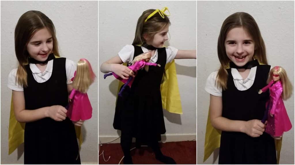 A young girl with light brown hair, wearing a black dress, white shirt, and yellow cape, smiles and plays with a blonde Barbie doll in a pink dress. The collage shows her posing with the doll and pretending to be a superheroine.